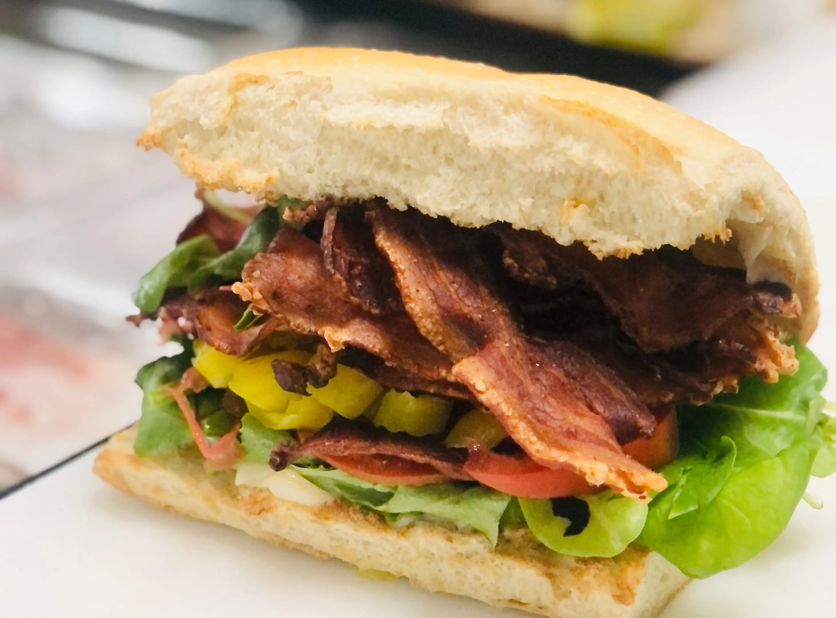 111 A sandwich with bacon, lettuce and tomato on it.