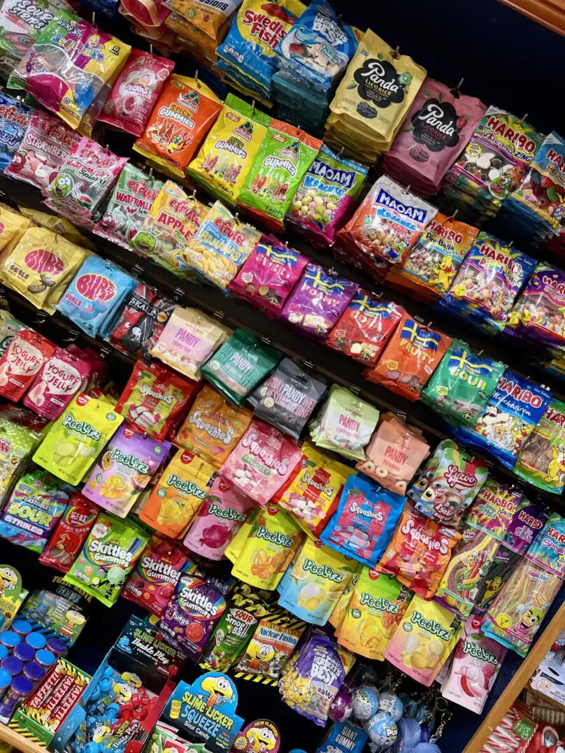 Variety of colorful candy bags on shelves.